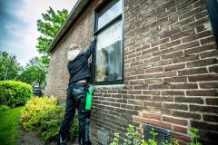 Glazenwasser is bezig met zijn werkzaamheden